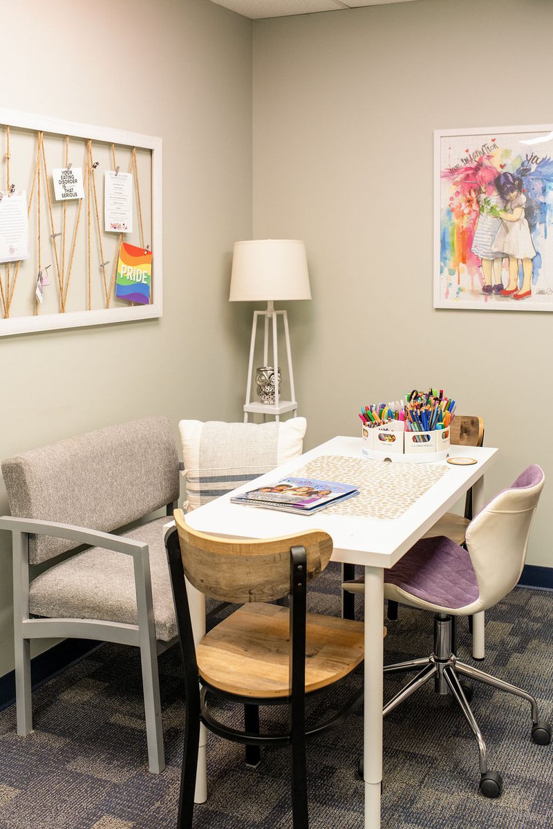 A cozy community room at the Balanced Nutrition Therapy office with a table, chairs and art supplies