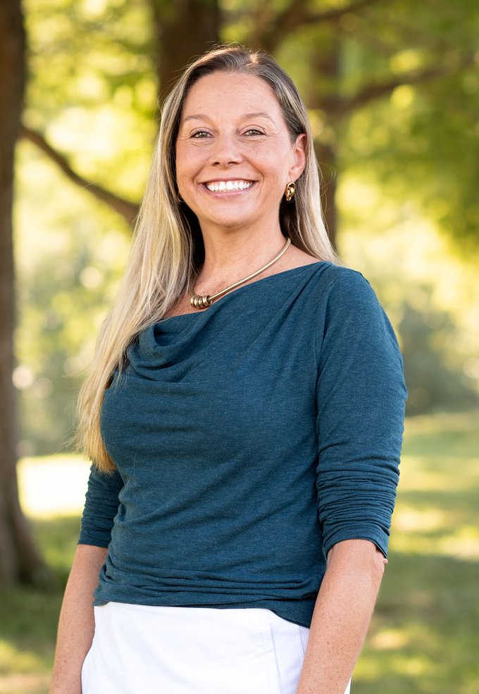 Deborah Hinds, NDTR, smiling outdoors under the trees