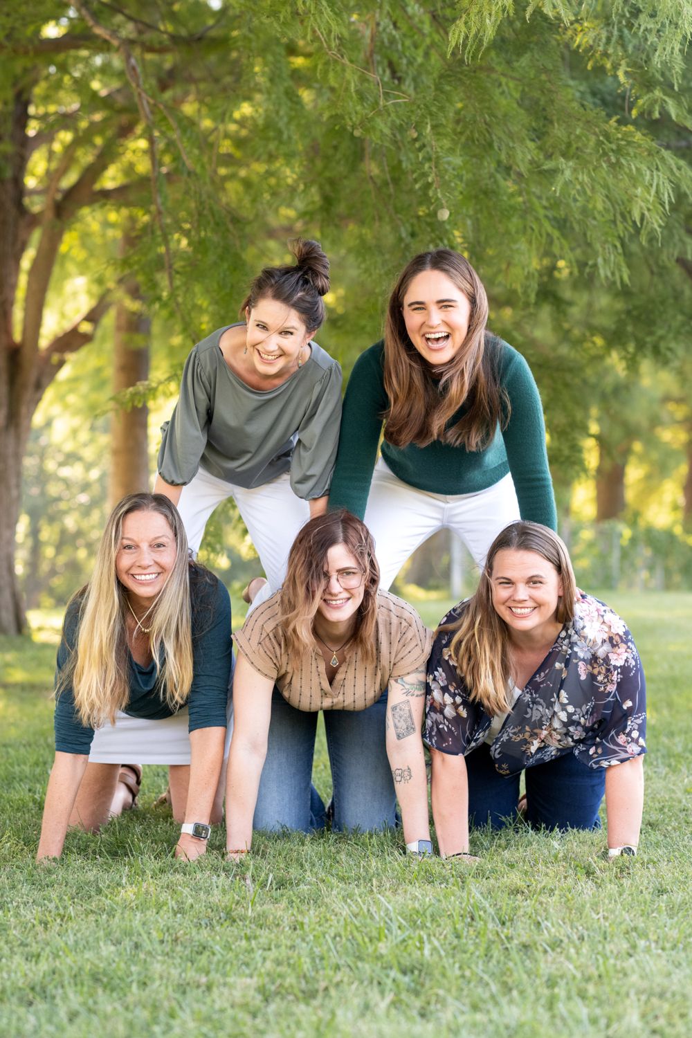The Balanced Nutrition Therapy team laughing together in a human pyramid on the grass